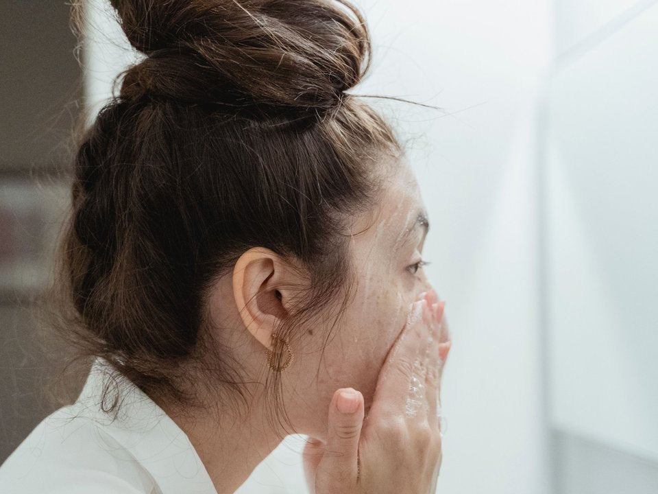 Woman washing her face after a shower